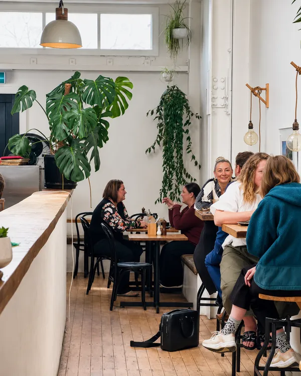 Guests sitting together inside the plant-filled café